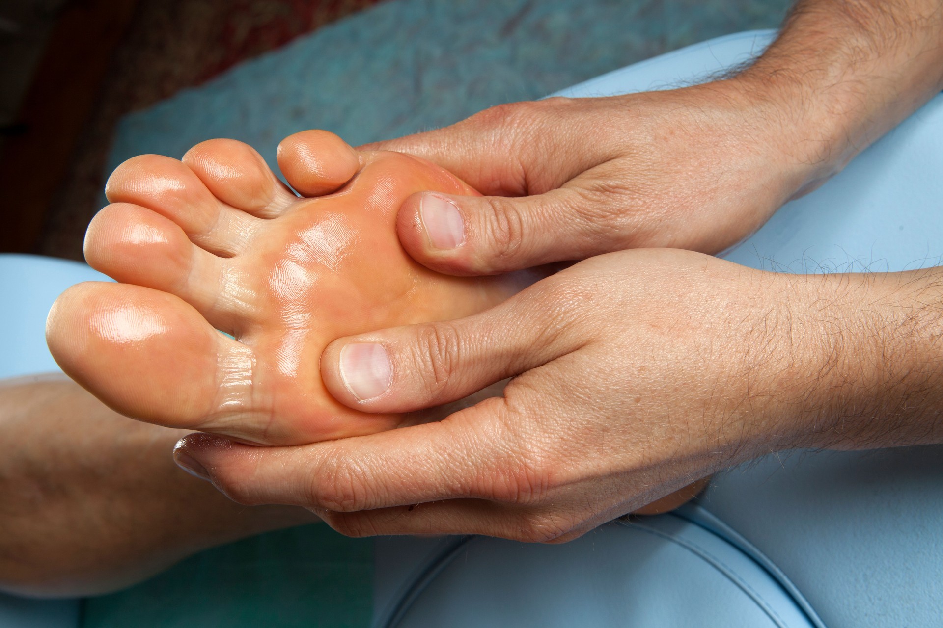 Human hands massaging man's foot